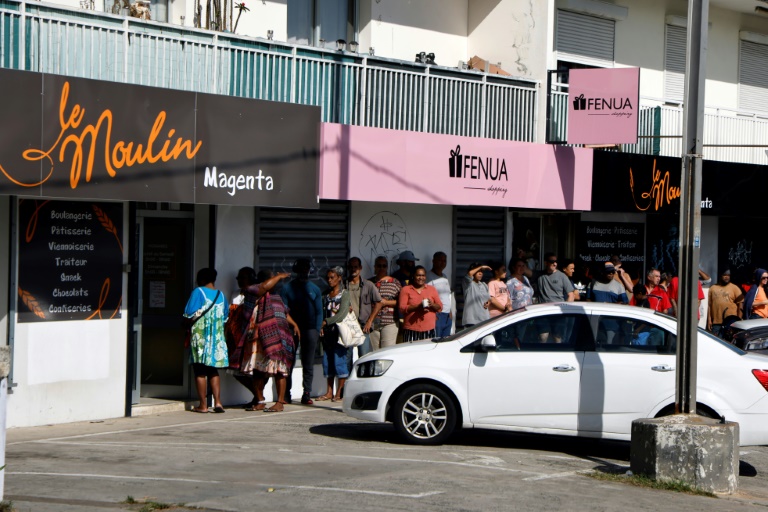 Des habitants font la queue pour acheter du pain dans le quartier de Magenta, à Nouméa, le 23 mai 2024 en Nouvelle-Calédonie