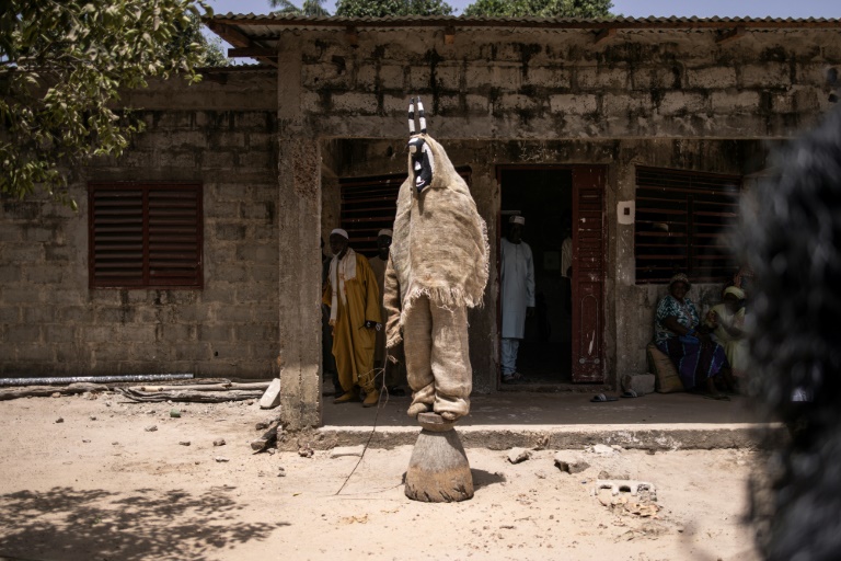 Un homme exécute une danse avec un masque traditionnel devant la maison d'Oumar Diemé, 91 ans (non photographié), un ancien tirailleur sénégalais, à Badiana, le 14 mai 2024