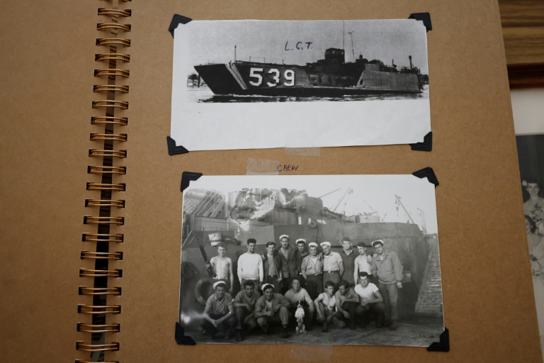 Le vétéran américain Richard Rung montre des photos de la barge de débarquement et de l'équipage dans lequel il a servi lors de la Seconde Guerre mondiale, le 27 mars 2024 à Carol Stream, dans l'Illinois