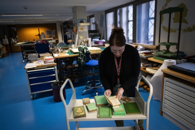 Aude Therstappen, conservatrice de la BNU (Bibliothèque nationale et universitaire) à Strasbourg, examine des livres colorés en vert avec l'arsenic, le 17 mai 2024