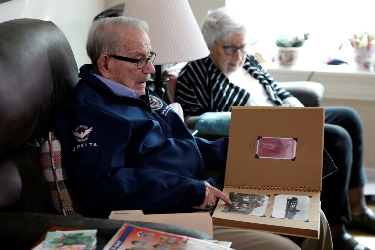 Le vétéran américain Richard Rung regarde des vieilles photos près de son épouse Dorothy, à Carol Stream, le 27 mars 2024 dans l'Illinois