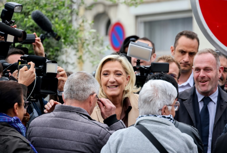 Marine Le Pen (C), au côté de Steeve Briois (D), maire RN d'Hénin-Beaumont, en déplacement de campagne à Hénin-Beaumont, dans le Pas-de-Calais, le 14 juin 2024