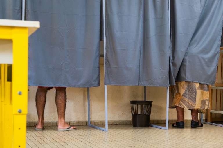 Des électeurs votent dans un isoloir au premier tour des législatives à Sainte Rose, en Guadeloupe, le 29 juin 2024