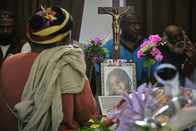 Un homme se recueille devant le portrait de Stéphanie Nasaie Doouka, tuée pendant les émeutes, lors de ses funérailles à Nouméa, le 1er juin 2024