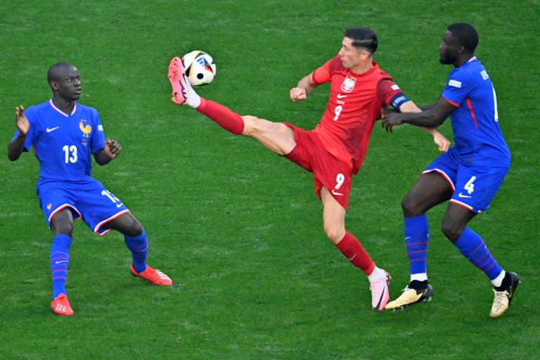 La défense française tente de stopper Robert Lewandowski (au centre), durant le match France-Pologne à Dortmund, le 25 juin 2024
