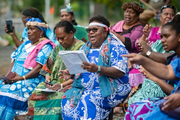 Des habitantes du quartier de Jacaranda, chantent lors d'une messe célébrée sur un barrage à Dumbéa, le 2 juin 20244 en Nouvelle-Calédonie