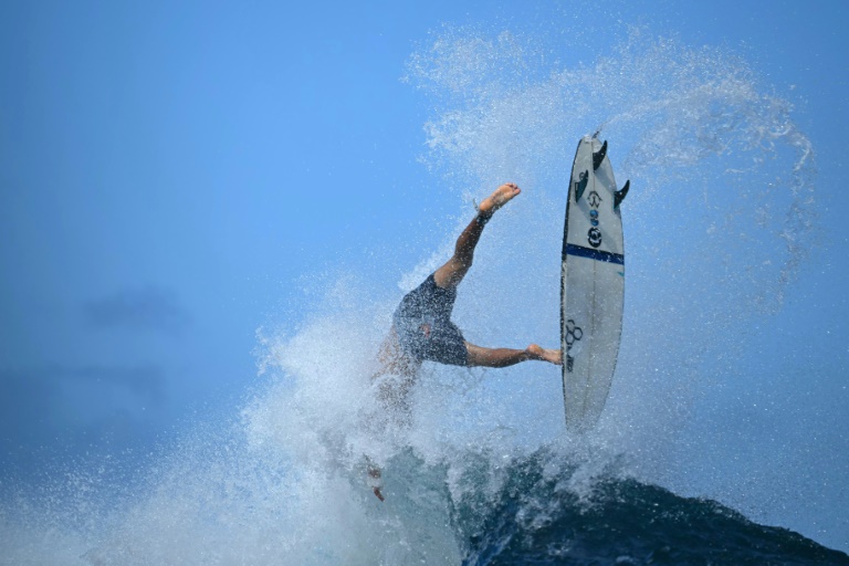 Un surfeur est submergé le 23 mai 2024 lors des qualifications pour le Tahiti Pro par la vague de Teahupo'o, à Tahiti, où se dérouleront les épreuves de surf aux JO 2024