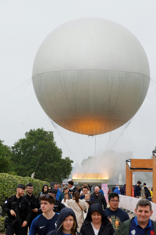 Des visiteurs devant la vasque olympique aux allures de montgolfière posée dans le jardin des Tuileries, le 27 juillet 2024 à Paris