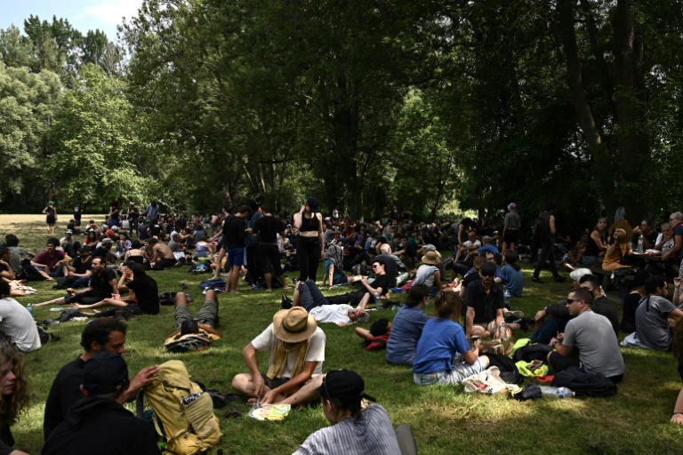 Des manifestants pique-niquent avant le début d'une marche contre la construction d'un réservoir d'eau géant (méga-bassine) près de Migne-Auxances, le 19 juillet 2024 dans la Vienne