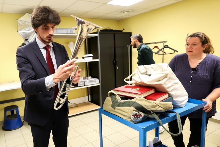 Baptiste Portay, commissaire-priseur, évalue un trombone à coulisse pour proposer un prix à sa propriétaire,, le 16 juillet 2024 au Crédit Municipal de Lille, dans le Nord