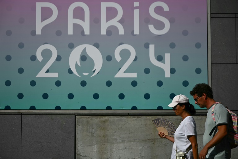 Une femme s'évente sous la chaleur pendant les JO-2024 devant l'Arena Paris Sud à Paris, le 29 juillet 2024