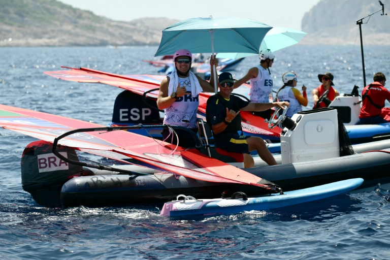 Le Brésilien Mateus Isaac attend de meilleures conditions météorologiques avant une épreuve masculine de planche à voile IQFoil aux JO-2024 au port de plaisance du Roucas-Blanc à Marseille, le 28 juillet 2024