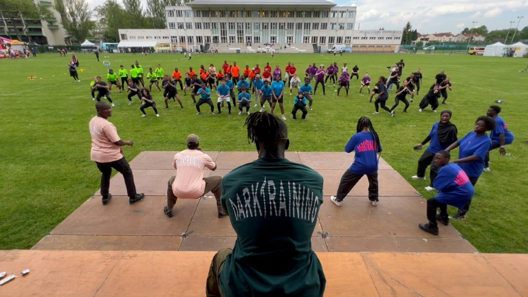 Cette capture d'écran d'une séquence vidéo de l'AFP montre Ibrahima Balde, entraîneur sportif, dirigeant un entraînement avec des jeunes riverains lors des « journées sportives environnementales » à Sevran, le 12 mai 2024