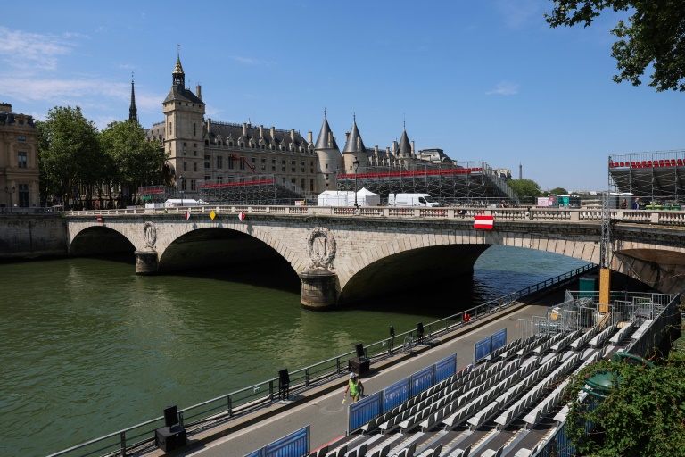 Un ouvrier marche près des gradins installés pour la cérémonie d'ouverture des JO-2024 à proximité de la Conciergerie, le 19 juillet 2024 à Paris