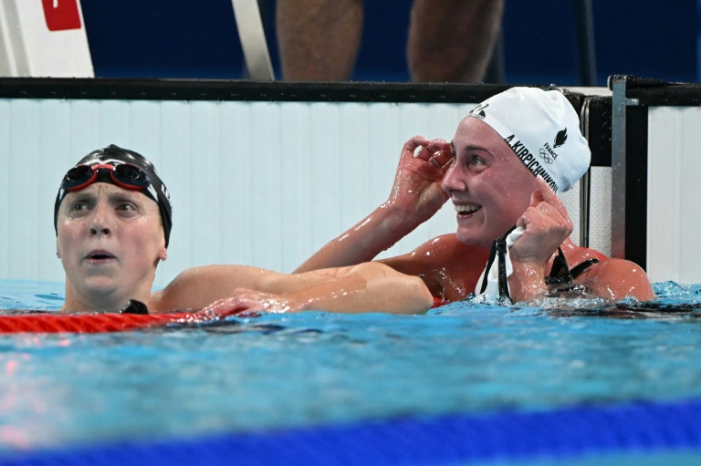 La nageuse française Anastasiia Kirpichnikova (D) célèbre sa médaille d'argent sur le 1500 m nage libre des Jeux olympiques de Paris au côté de la médaillée d'or américaine Katie Ledecky, à Nanterre, le 31 juillet 2024