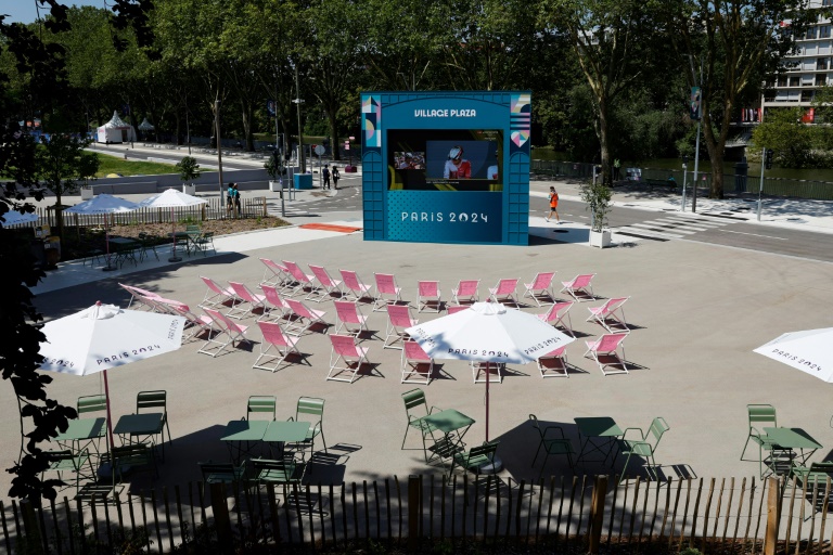 Un écran de télévision géant et des chaises longues au village olympique des athlètes, le 18 juillet 2024 à Saint-Denis, au nord de Paris