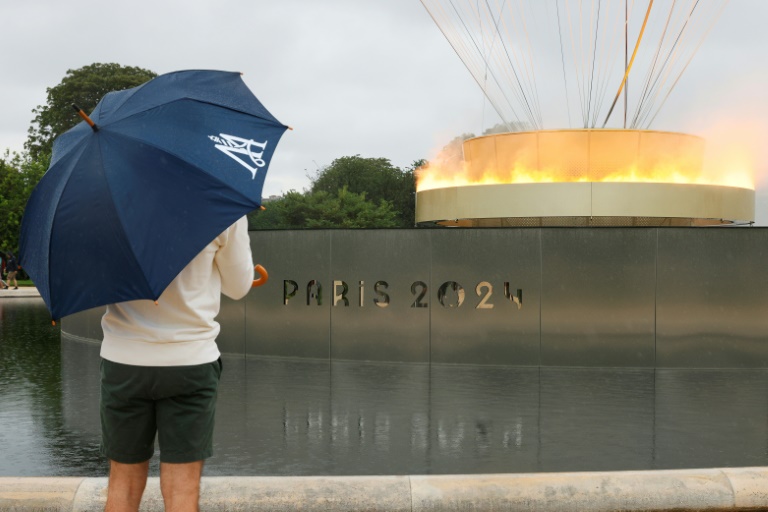 Un visiteur vient regarder la vasque olympique aux allures de montgolfière posée dans le jardin des Tuileries, le 27 juillet 2024 à Paris