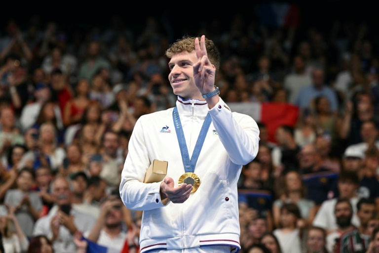 Le nageur français Léon Marchand sur le podium avec sa médaille d'or après sa victoire sur le 200 m papillon aux Jeux olympiques de Paris, à Nanterre, le 31 juillet 2024