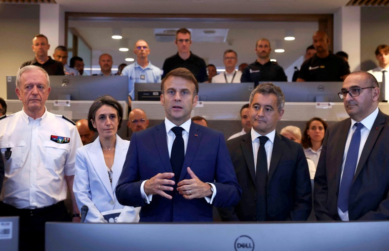 Le président Emmanuel Macron (C) s'exprime lors d'un déplacement au centre d'information et de commandement de la direction de l'ordre public et de la circulation à la Préfecture de police de Paris, le 27 juillet 2024