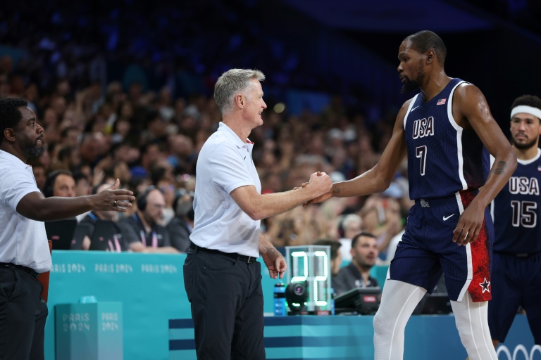 Le basketteur américain Kevin Durant tape dans la main de son entraineur Steve Kerr lors de la rencontre des Jeux olympiques de Paris entre les États-Unis et la Serbie, à Villeneuve-d'Ascq, en France, le 28 juillet 2024