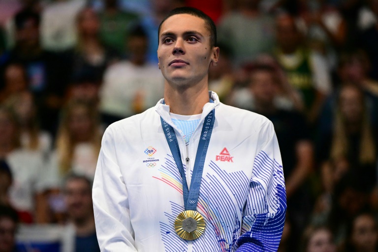 Le nageur roumain David Popovici avec sa médaille d'or au coup après son titre olympique sur 200 m nage libre, à Nanterre, le 29 juillet 2024