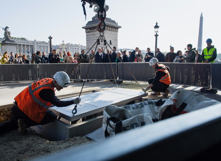 Des ouvriers installent des équipements électriques sur la place de la Concorde à Paris le 19 avril 2023 en vue des JO-2024