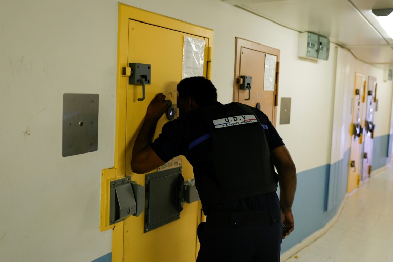 Un surveillant regarde par l'oeilleton d'une porte de cellule de l'Unité pour détenus violents de la prison de Fleury-Mérogis, en Essonne, le 21 juin 2023