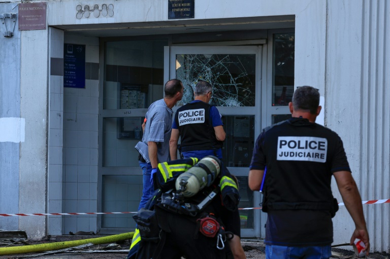 Des policiers inspectent l'immeuble où un incendie qui s'est déclaré dans la nuit de mercredi à jeudi a fait sept morts, le 18 juillet 2024 à Nice