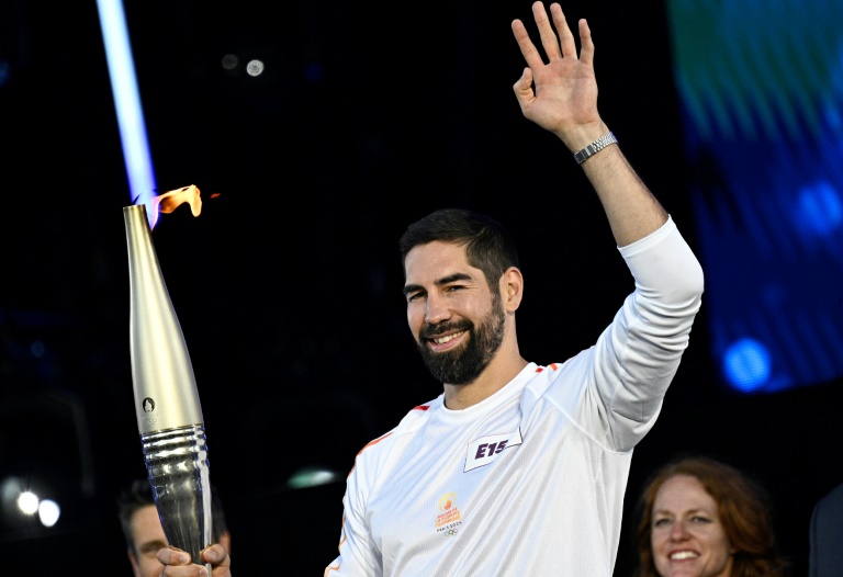 Le handballeur français Nikola Karabatić porte la flamme olympique, sur la place de la République, à Paris, en France, le 15 juillet 2024