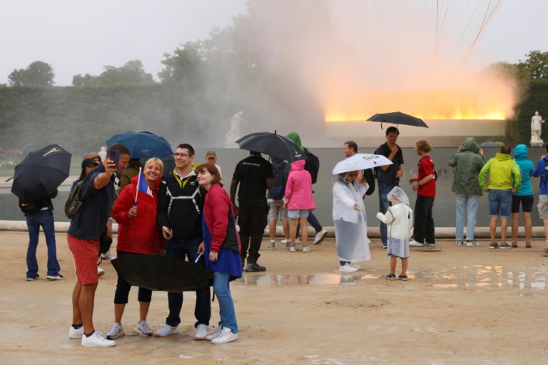 Des visiteurs devant la vasque olympique aux allures de montgolfière posée dans le jardin des Tuileries, le 27 juillet 2024 à Paris