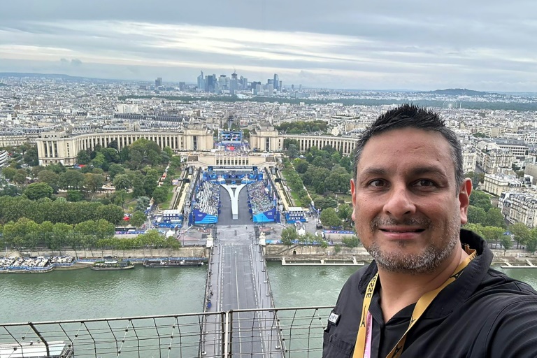 Le photographe de l'Agence France-Presse Luis Robayo prend un selfie depuis la tour Eiffel avant la cérémonie d'ouverture des JO, le 26 juillet 2024 à Paris