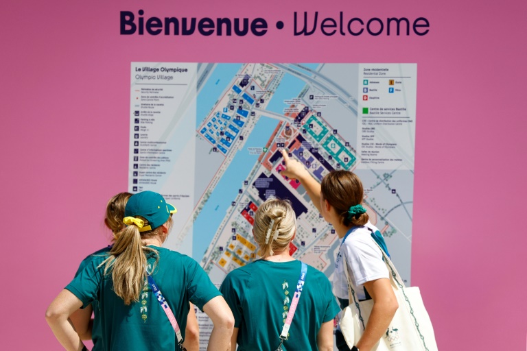 Des membres de l'équipe des athlètes d'Australie regardent la carte du village olympique, le 18 juillet 2024 à Saint-Denis, au nord de Paris