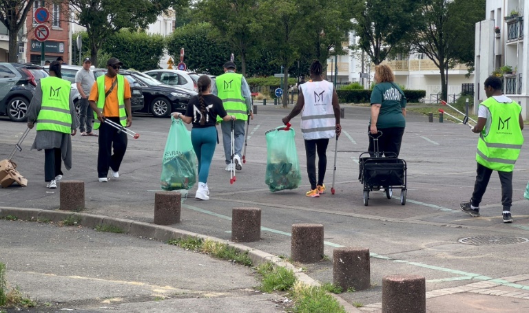 Cette capture d'écran d'une vidéo de l'AFP montre de jeunes habitants du quartier ramassant des déchets à Sevran, dans la banlieue nord-est de Paris, le 21 juillet 2024