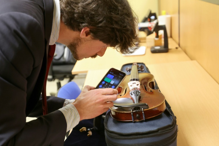 Baptiste Portay, commissaire-priseur, évalue un violon pour proposer un prix à son propriétaire,, le 16 juillet 2024 au Crédit Municipal de Lille, dans le Nord