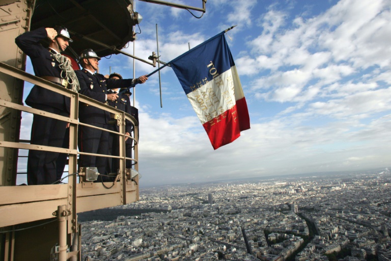 Des pompiers déploient un drapeau tricolore sur la tour Eiffel le 25 août 2004 en hommage à leurs collègues qui ont hissé l'étendard le 25 août 1944 en pleine bataille pour la libération de Paris