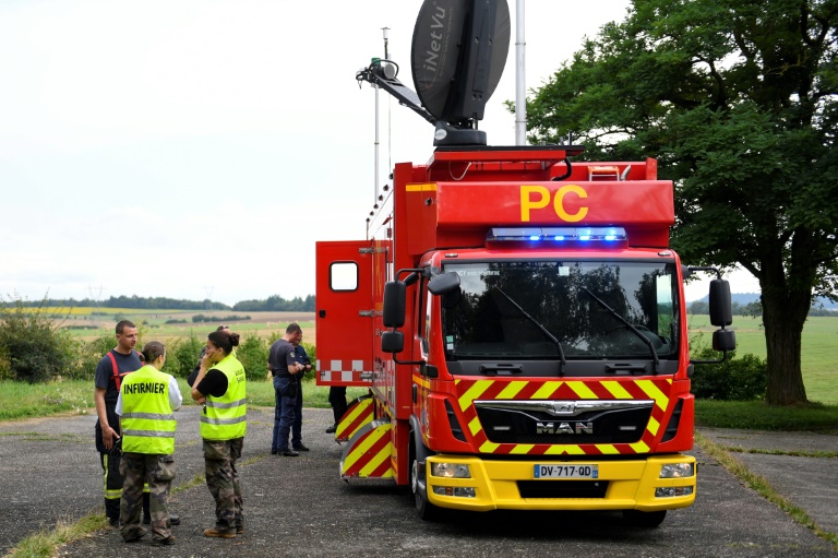 Une infirmière se tient près d'un véhicule de poste de commandement des pompiers à Colombey-les-Belles, dans l'est de la France, le 14 août 2024, à la suite d'un accident entre deux avions militaires