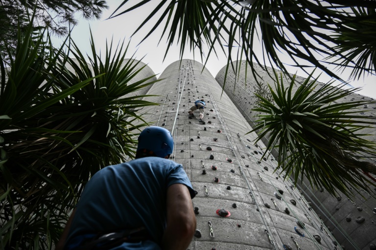 Un grimpeur sur d'anciens silos à grain reconvertis en mur d'escalade, à Bordeaux, le 7 août 2024