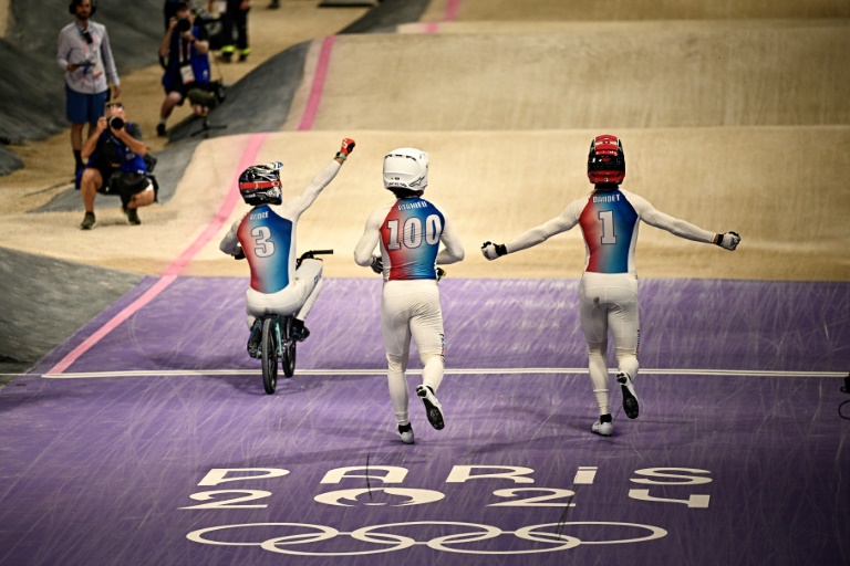 Le médaillé d'or français de BMX Racing Joris Daudet (au centre), avec le médaillé d'argent Sylvain André (à gauche) et le médaillé de bronze Romain Mahieu (à droite) lors des Jeux olympiques de Paris à Saint-Quentin-en-Yvelines, le 2 août 2024