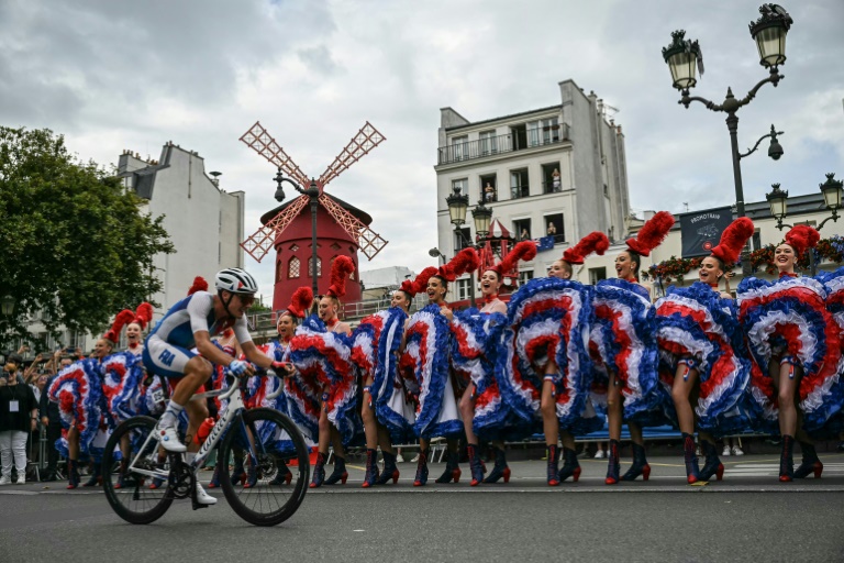 Le Français Valentin Madouas passe devant le Moulin Rouge lors de la course en ligne des JO, le 3 août 2024 à Paris