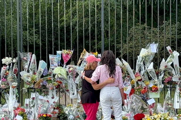 Anouchka Delon (d), la fille d'Alain Delon, se recueille devant les fleurs et les messages déposés pour l'acteur décédé, le 21 août 2024 à Douchy, dans le Loiret