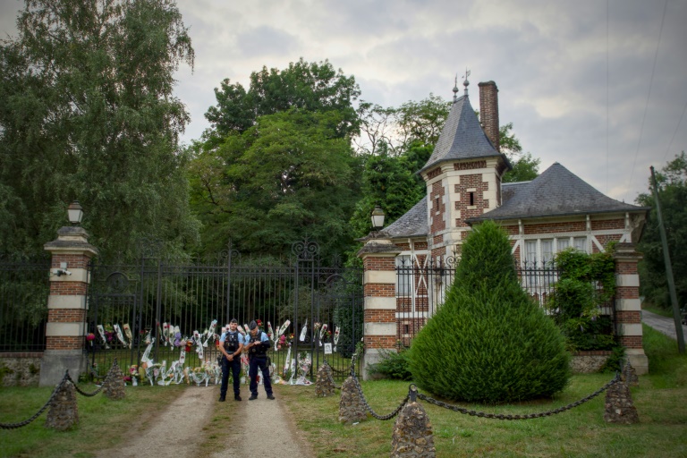 Des gendarmes sont stationnés devant l'entrée de la propriété de l'acteur français Alain Delon, avec des fleurs déposées sur et à côté du portail, à Douchy, dans le centre de la France, le 18 août 2024