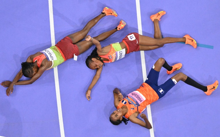 L'athlète kényane Beatrice Chebet (au centre), la Kenyane  Faith Kipyegon (à gauche) et la Néerlandaise Sifan Hassan après le 5.000 m remporté par Chebet lors des Jeux olympiques de Paris au Stade de France à Saint-Denis le 5 août 2024