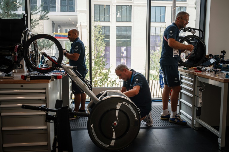 Les techniciens s'affairent à remettre en état les fauteuils, dont ici un de course, au centre de réparation du Village paralympique