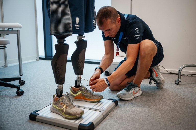 Un technicien ajuste la prothèse de jambe d'un para-athlète français, Alexis Sanchez, au centre de réparation du Village paralympique