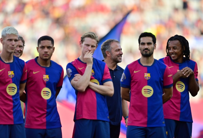 Le nouvel entraîneur du FC Barcelone, l'Allemand Hansi Flick, entouré de ses joueurs, avant le trophée Gamper contre Monaco, le 12 août 2024 à Barcelone