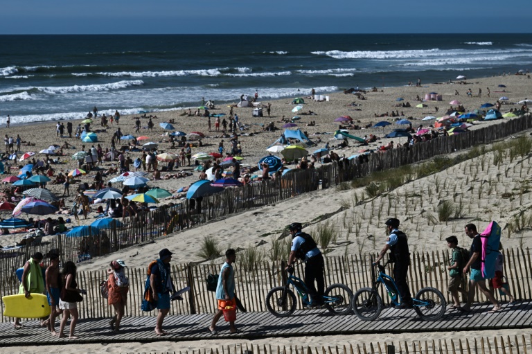 Des gendarmes, en scooters électriques tout-terrain, patrouillent le long d'une plage à Lacanau, le 8 août 2024 en Gironde