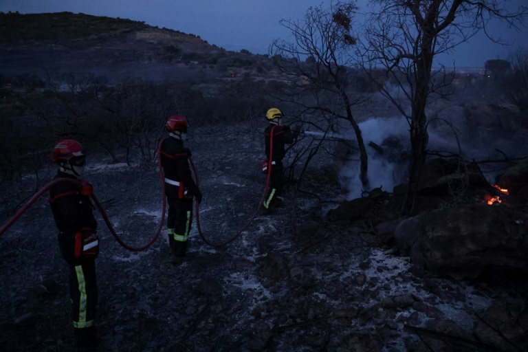 Des pompiers étéignent un foyer d'incendie près de Frontignan, dans l'Hérault, le 18 août 2024