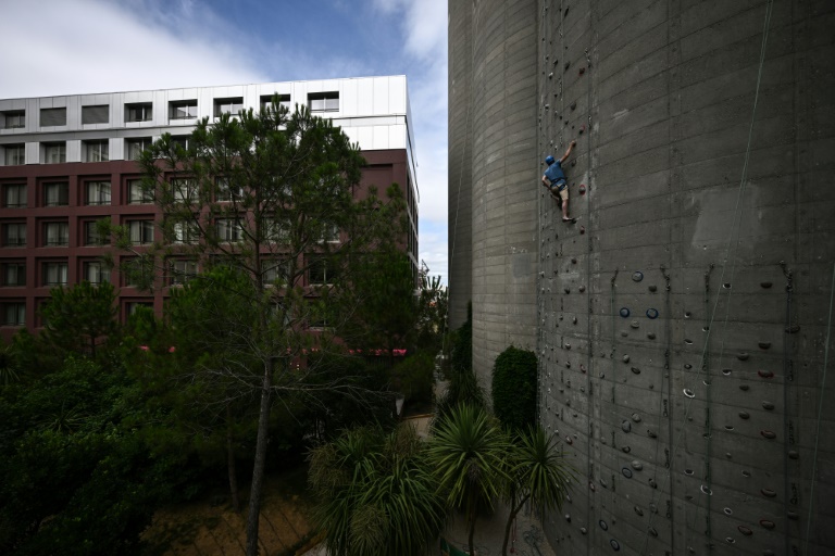 Un grimpeur sur d'anciens silos à grain reconvertis en mur d'escalade, à Bordeaux, le 7 août 2024