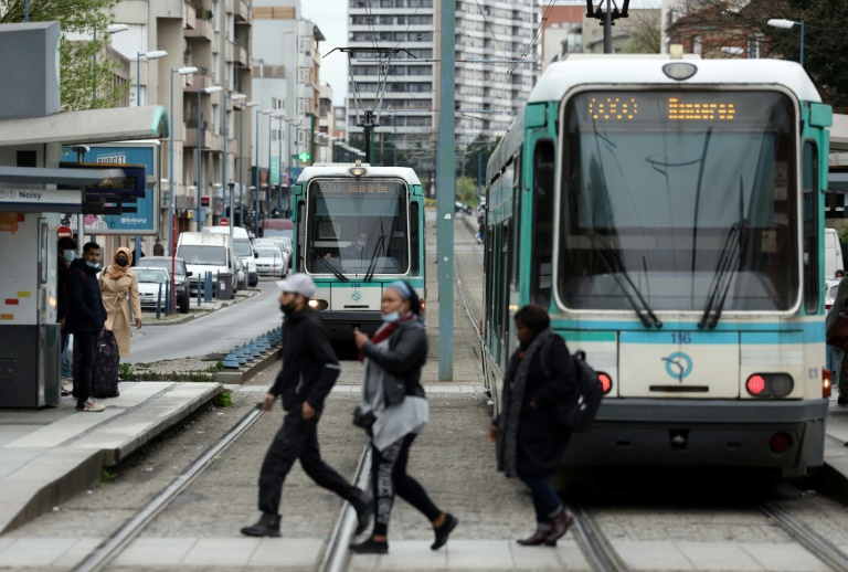 Des personnes traversent devant un tramway à Bobigny, le 6 avril 2022, sur les lieux de la mort de Jérémie Cohen, renversé par un tramway le 16 février 2022