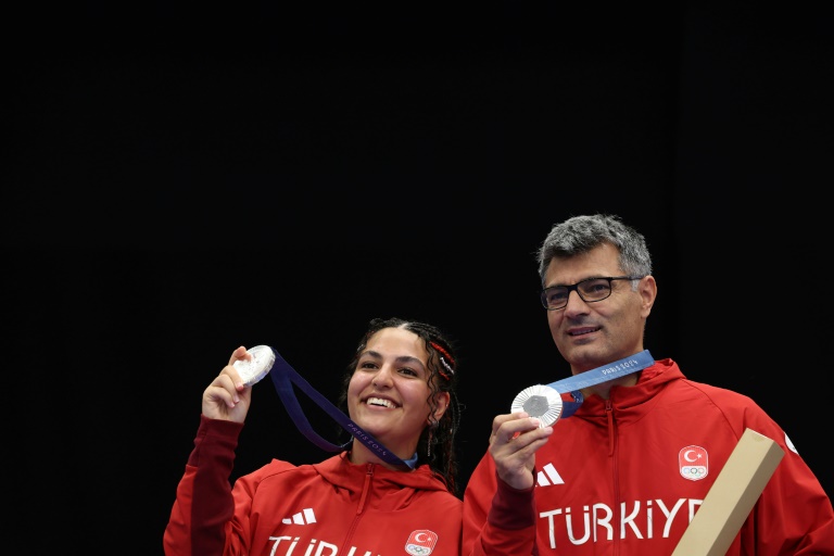 Les médaillés d'argent turcs Sevval Ilayda Tarhan et Yusuf Dikec posent sur le podium après le match pour la médaille d'or par équipes mixtes au pistolet à air comprimé à 10 m, le 30 juillet 2024 à Châteauroux, pour les JO de Paris